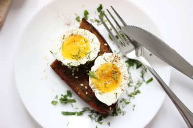 Kavrulmuş tost susam ve beyaz arka plan üzerinde izole dereotu ile haşlanmış yumurta yarım. Lezzetli sağlıklı kahvaltı gıda. 
