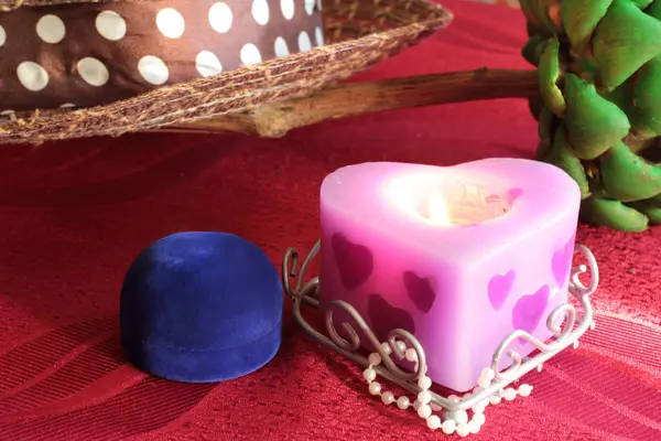 yanan bir mum ve bir çiçek ile natürmort