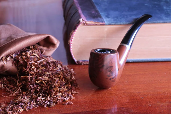 burnt tobacco pipe and book