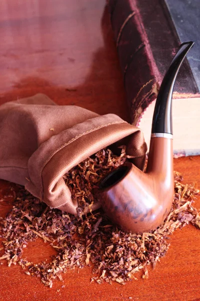 smoking pipe pouch tobacco and old book