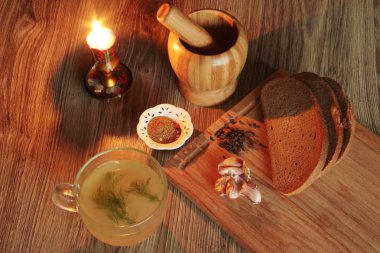 et suyu mum ve ahşap arka plan üzerinde baharatlar ile kupa