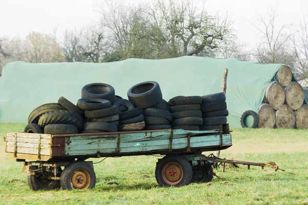 Использованные шины лежат на тележке трактора — стоковое фото