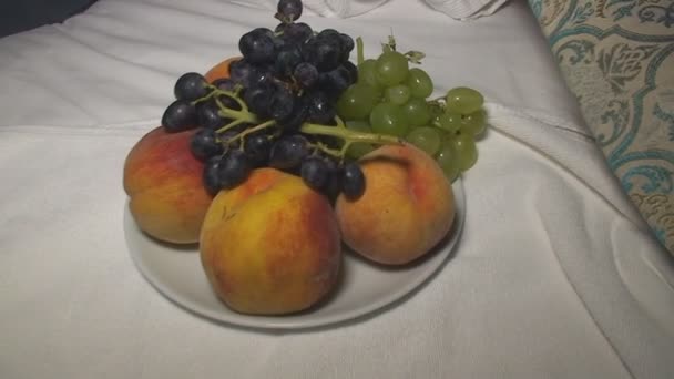 Натюрморт з вишнею, виноградом та персиком за столом — стокове відео