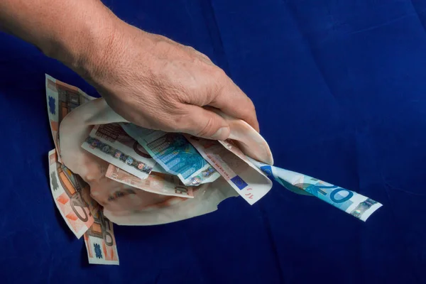 El, içinde farklı değerlerde Avro banknotları bulunan bir deniz kabuğu alır.