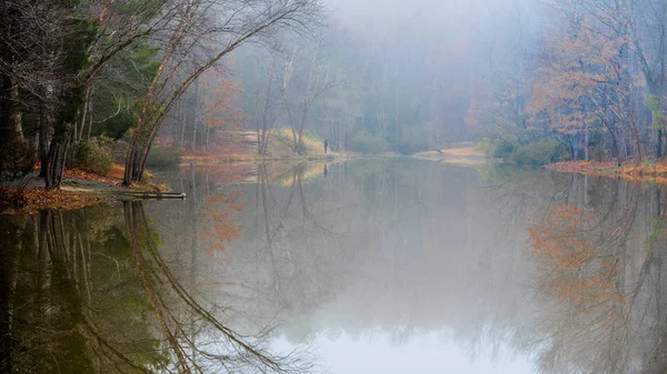 Uomo Pesca Sul Lago Inverno Circondato Colori Riflessi Autunnali — Foto Stock