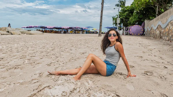 Mujer Joven Con Gafas Sol Sentada Playa Con Sombrillas Detrás — Foto de Stock