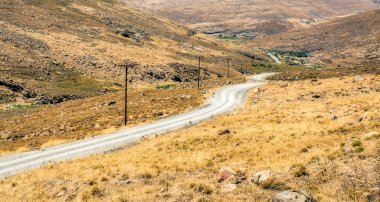 Kavuran güneş fırça ile çevrili bir vadide virajlı yol