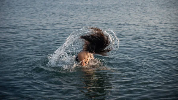 青少年在水中翻转头发 使飞溅 — 图库照片