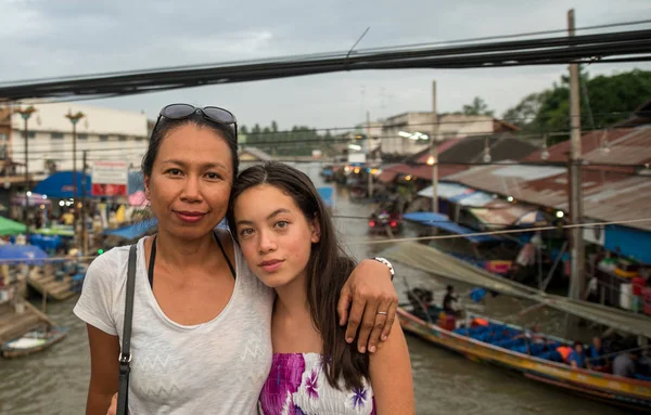 Woman and teen standing at floating market