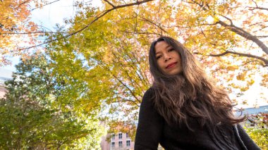 Taylandlı kadın sonbaharda renkli ağaç altında duran