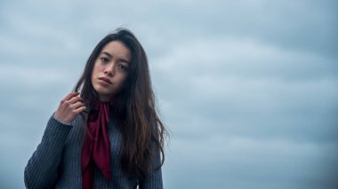 Genç Asyalı-Amerikalı bordo eşarp ile kışın Kuzey Carolina Beach