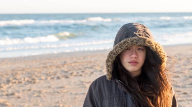 Genç Asyalı-Amerikalı North Carolina Beach deki kapüşonlu parka kışın