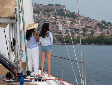 Anne ve kızı stadning bir sailbot Molyvos lesvos arka plan ile ön