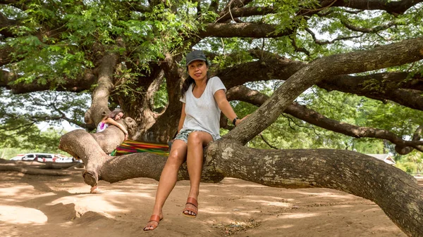 Madre e hija sentadas en la rama del árbol del Monkeypod gigante — Foto de Stock