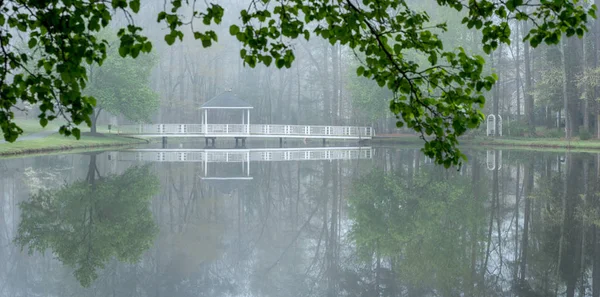 Gazebo na ponte passando sobre lagoa — Fotografia de Stock