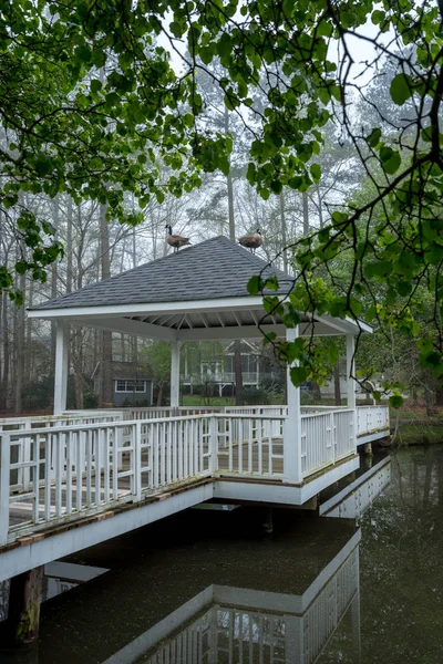 Gazebo na ponte passando sobre lagoa — Fotografia de Stock