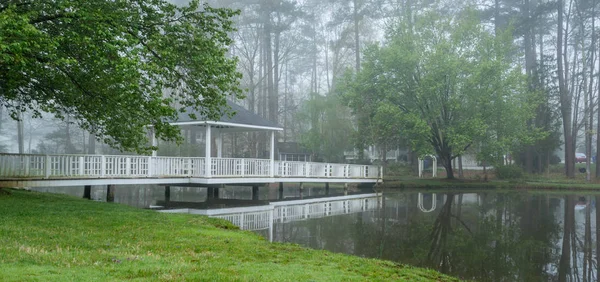 Gazebo on bridge going over pond — Stock Photo, Image