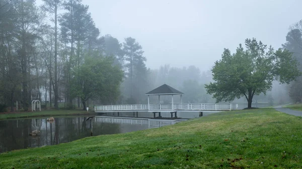 Gazebo on bridge going over pond — Stock Photo, Image