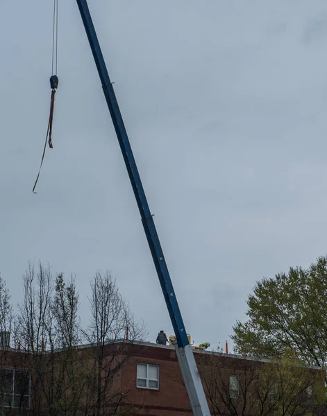 Dos trabajadores en un tejado con grúa — Foto de Stock