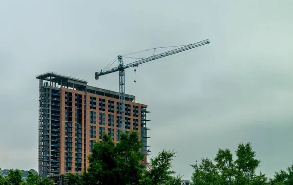 Grúa azul frente a un edificio alto en construcción — Foto de Stock