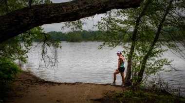 Nehrin yanındaki patikada duran Orta Çağ kadını