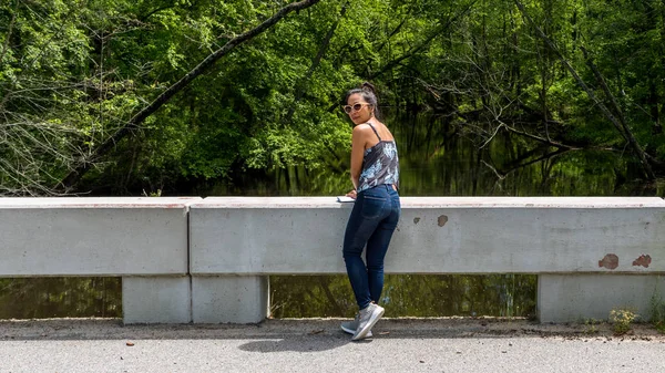 Mujer de pie en el puente cerca del río Swampy fuera de la carretera en Virgin — Foto de Stock