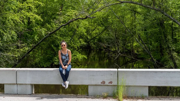 Mujer sentada en puente cerca del río Swampy en Virgini — Foto de Stock