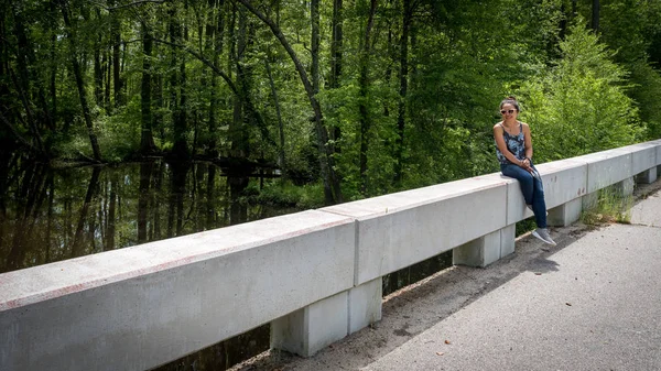 Mujer sentada en puente cerca del río Swampy en Virgini — Foto de Stock