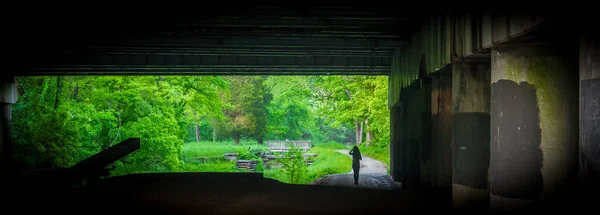 Женщина, идущая под мостом вдоль Чесапика и Огайо может — стоковое фото