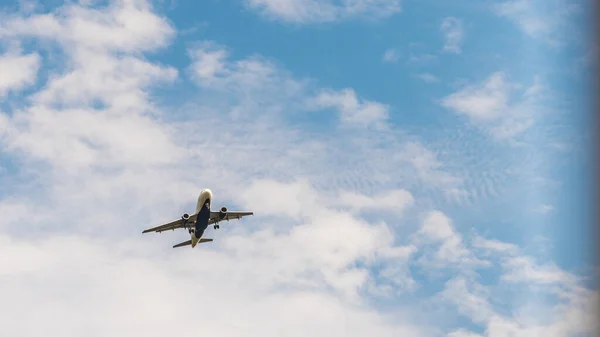 Jetliner v nízké výšce s mraky v pozadí — Stock fotografie