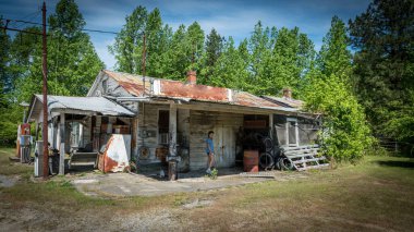 Terk edilmiş benzin istasyonunda duran genç genç