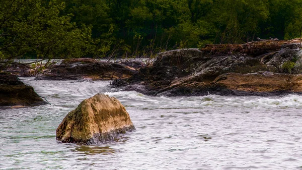 Large boulder in water on river in Great Falls National Park