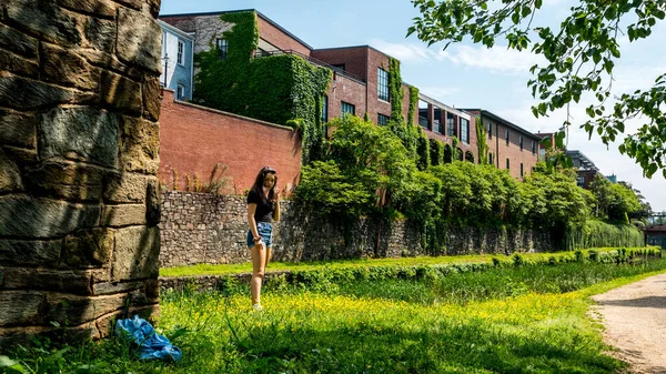 Teen ragazza in piedi in erba con pantaloncini blu e camicetta nera — Foto Stock
