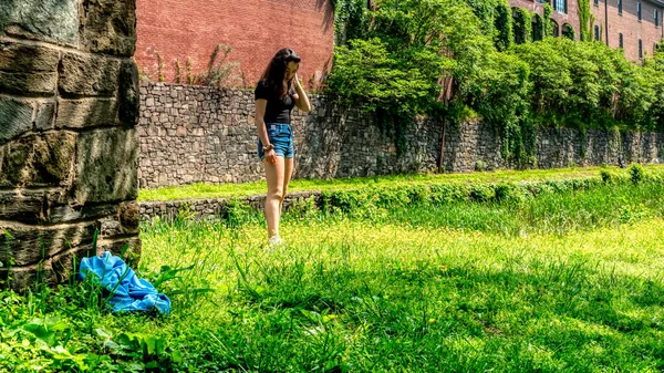 Дівчина-підліток стоїть в траві і дивиться вниз — стокове фото