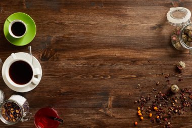 Çay ve kahve çeşitli türlü havai görünümü. Çeşitli otlar ve rustik ahşap tahta üzerinde kahve çekirdekleri ile aromalı. Boşaltmak
