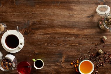 Çay ve kahve çeşitli türlü havai görünümü. Çeşitli otlar ve rustik ahşap tahta üzerinde kahve çekirdekleri ile aromalı. Boşaltmak