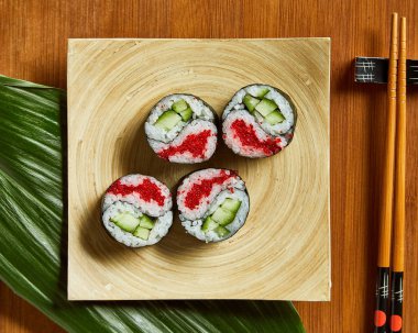 Ahşap plaka üzerinde havai görünümü chopsticks ve Japon Suşi. Yatay fotoğraf.