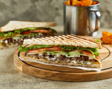 Sığır eti, domates ve salatalık sandviç görünümünü yakın çekim. Arka plan üzerinde çıtır çıtır kızarmış patates