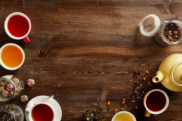 Overhead view of various sorts of tea and coffee. Flavoured with Assorted Herbs and coffee beans on a rustic wood board. Copyspace