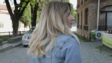 Kameradan uzaklaşan bir kadının arka görüntüsü. Eski Gürcistan şehrinde yalnızlığın ve özgürlüğün tadını çıkaran bir kadın.