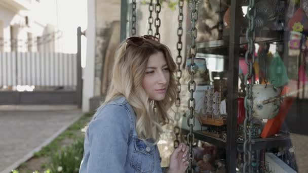 Young adult woman looking at gift shop storefront. Traveling. — Stock Video