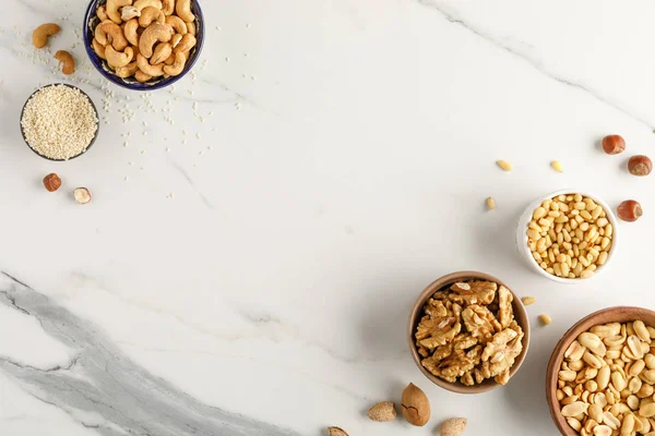 Frame made of different types of nuts in bowls Stock Photo