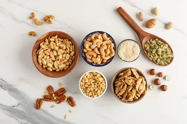 Vista de cerca de diferentes tipos de nueces en cuencos Imágenes De Stock Sin Royalties Gratis