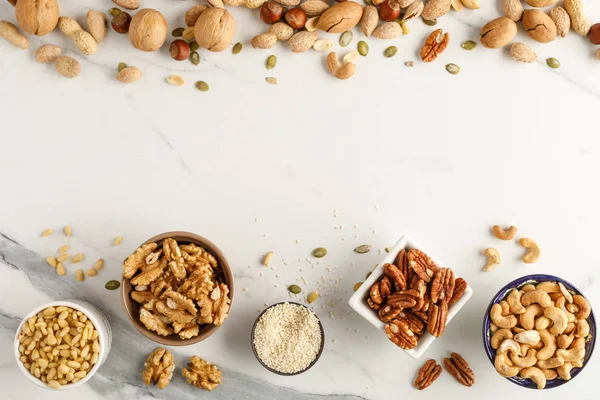 Frame made of different types of nuts in bowls Stock Photo