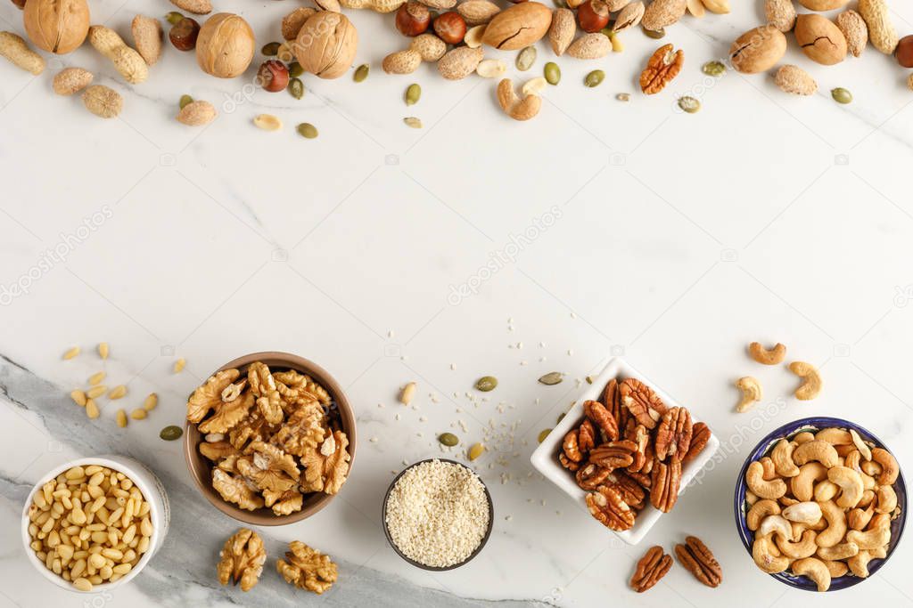 Frame made of different types of nuts in bowls