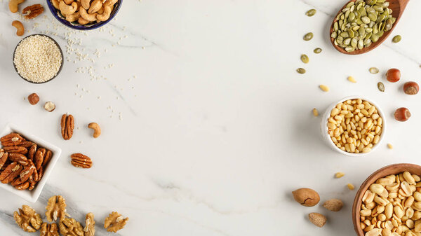 Frame made of different types of nuts in bowls