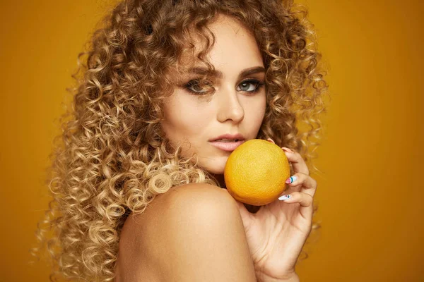 Afro saç modeli ile genç kızın güzellik portresi. Portakal meyvesi ile poz. — Stok fotoğraf