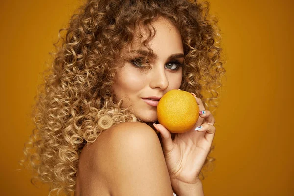 Afro saç modeli ile genç kızın güzellik portresi. Portakal meyvesi ile poz. — Stok fotoğraf