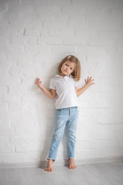 Longitud completa de hermosa niña en vestido de pie y posando sobre fondo blanco — Foto de Stock