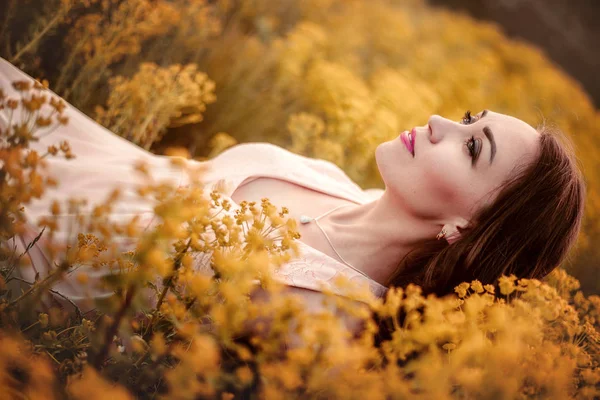 Молодая женщина наслаждается природой и солнечным светом в поле канолы — стоковое фото